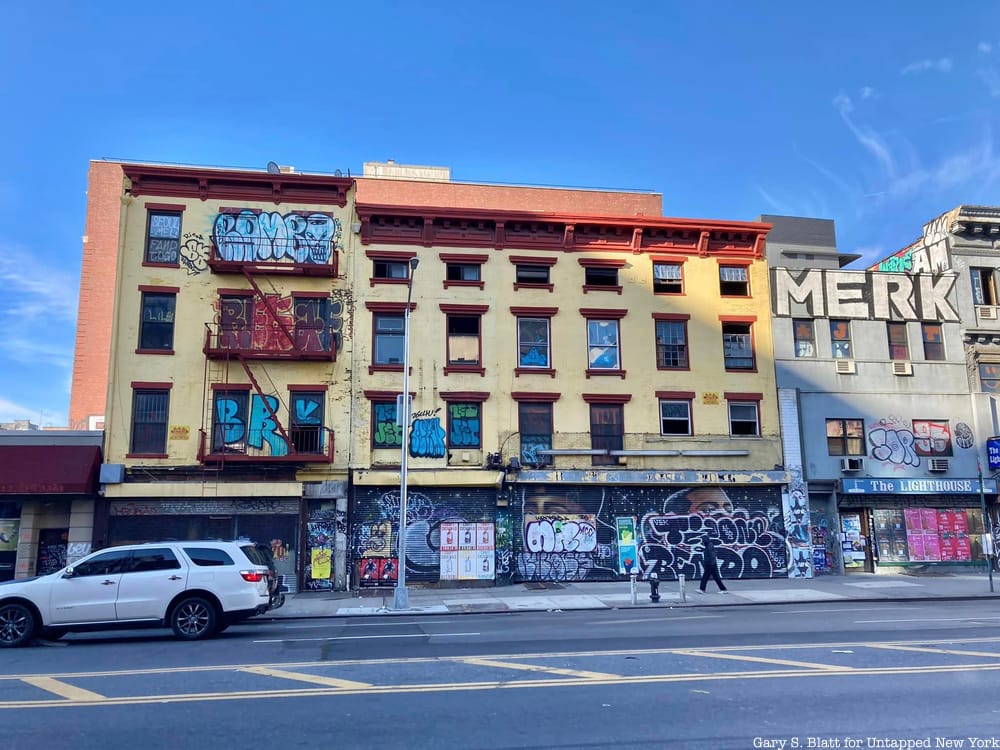 A series of yellow buildings on the Bowery with colorful graffiti