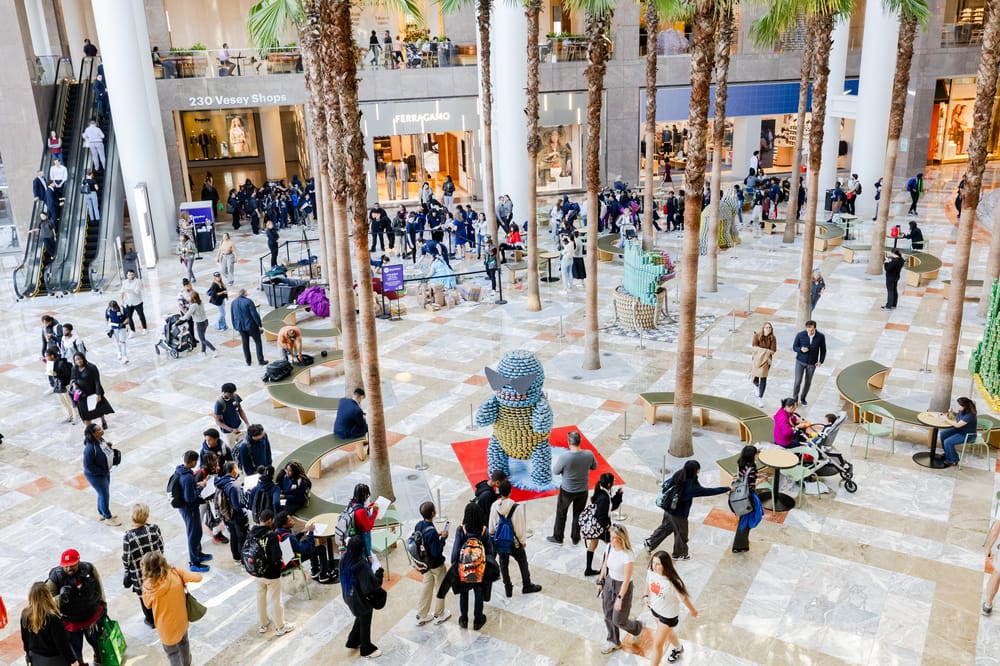 Overhead shot of Brookfield Place central atrium where crowds of peoplea are walking among Canstruction sculptures