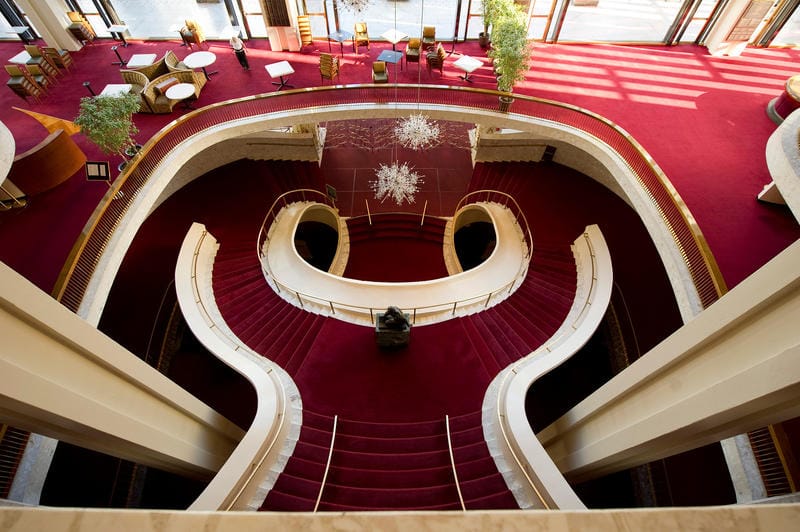 Overhead view of the red curving staircase in the lobby of the Met Opera