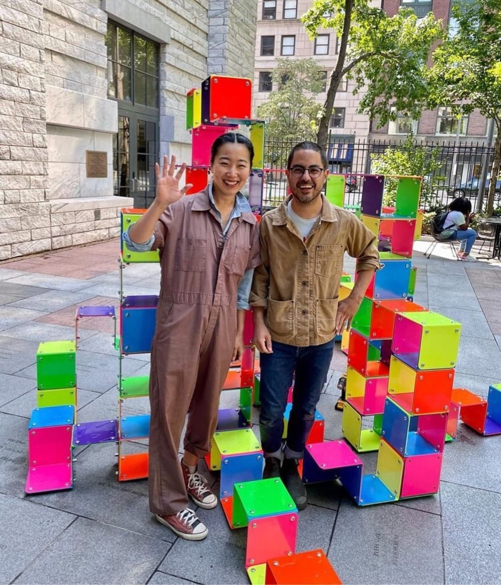 Yeju and Chat standing within a colorful block sculpture