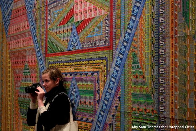 A photographer in front of "Ghost of a Dream: The Price of Happiness" by Lauren Was & Adam Eckstorm. (Photo by Aby Sam Thomas)