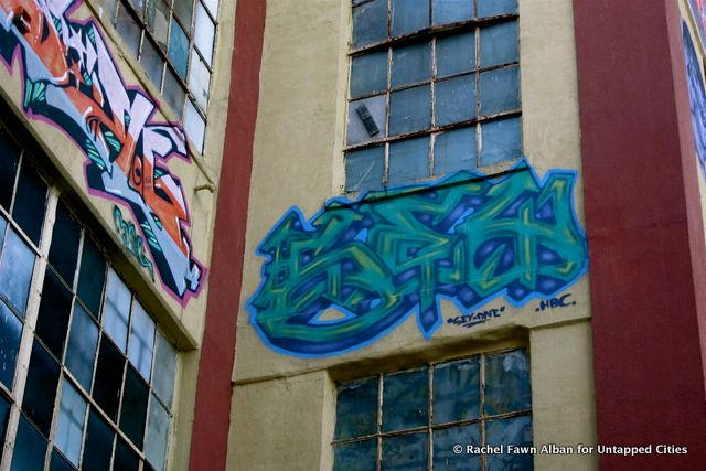 Sey One, a wheelchair-bound artist, was hoisted up 2 stories to do this blue green piece.