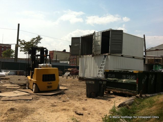 Two ship containers welded together on steel beams.