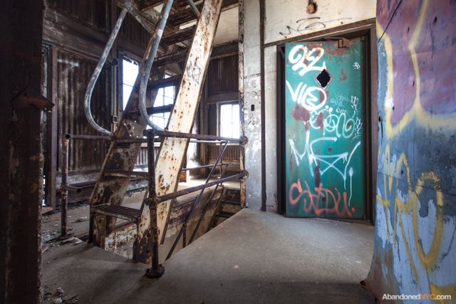 A 90-foot staircase of corroded metal slats connects the first floor to the top of the storage bins.