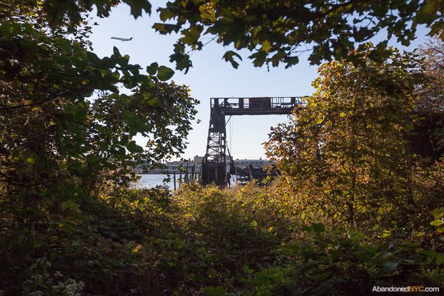 An airplane takes off from nearby LaGuardia airport with a gantry crane in view.