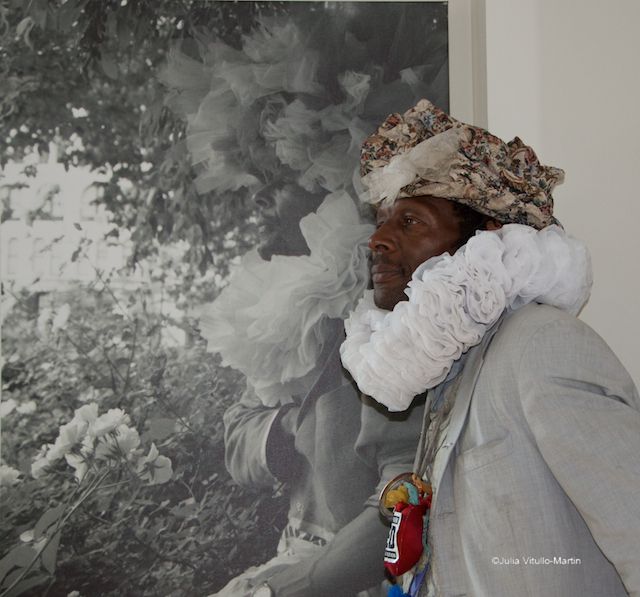 Artist Wendell Headley standing in front of a photo of himself by Felicia Gordon.