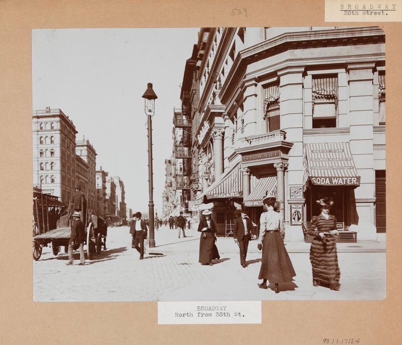 The corner of Broadway and 38th Street. Pedestrians and a street lamp are visible.