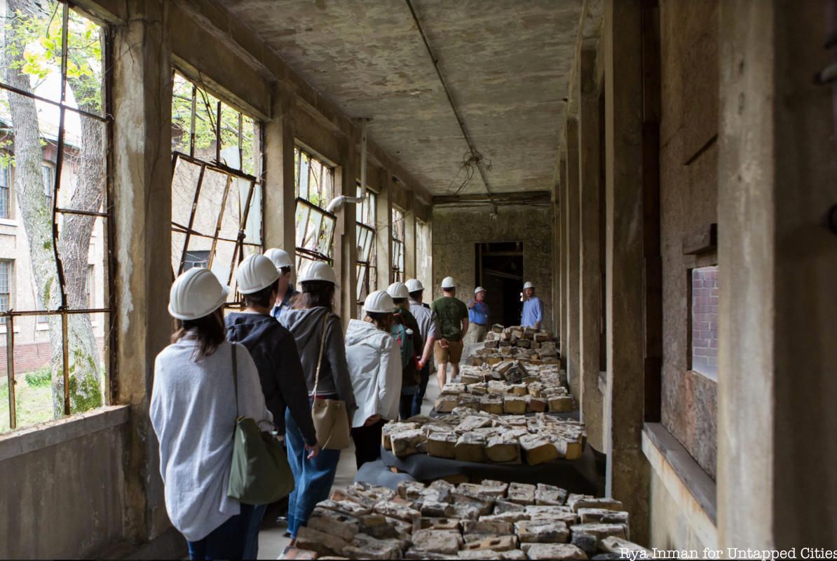 tour guests walking inside ellis island hospital