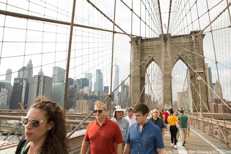 Group of tourgoers walking across the Brooklyn Bridge