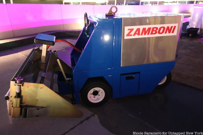 A zamboni next to the ice rink