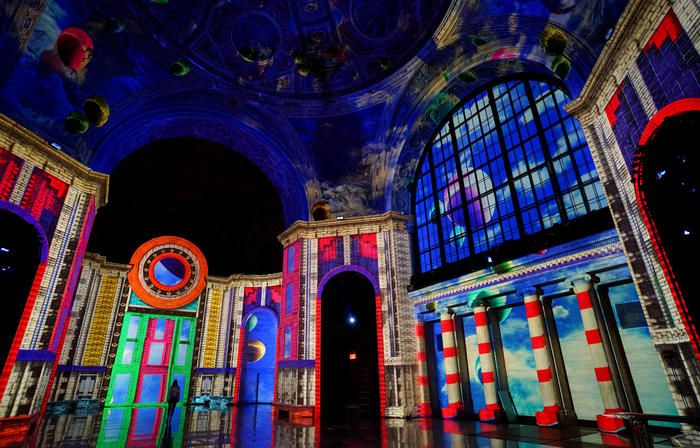 A rainbow colored image is projected onto the interior of the Cunard Building