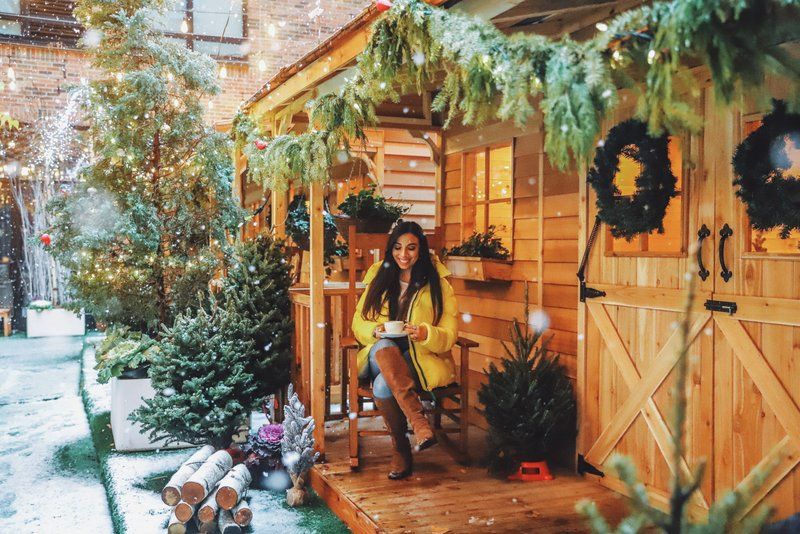 Woman sitting on cabin porch at Apres Arlo