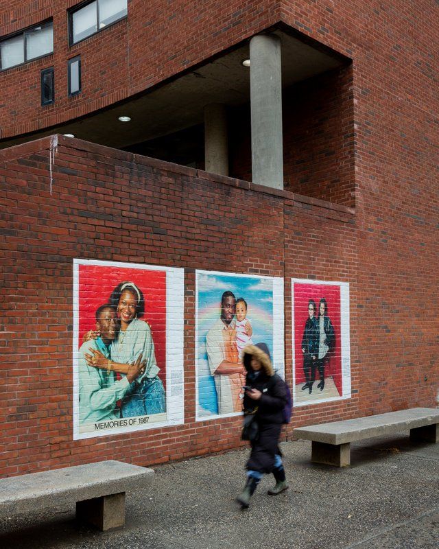 Enlarged photographs on brick wall of Rainbow Shoe Repair exhibition