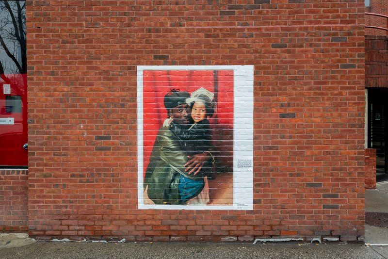 Father and daughter in photograph on brick wall