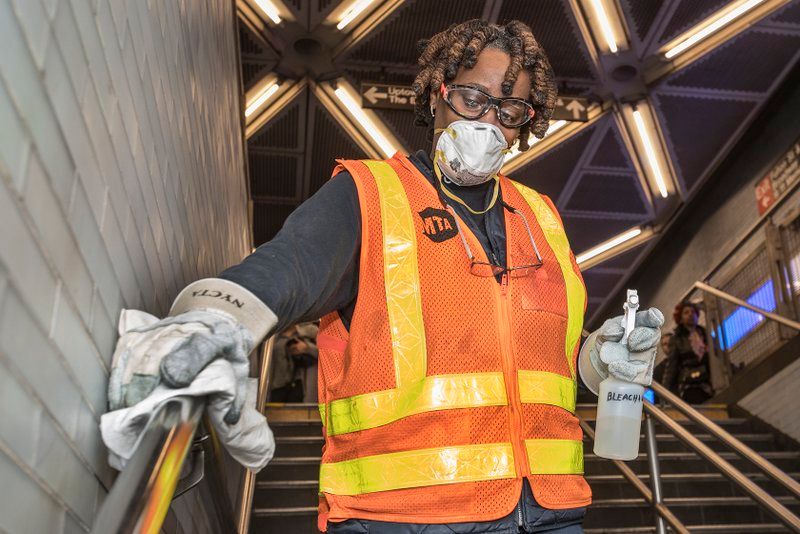 MTA workers disinfecting handrails in subway