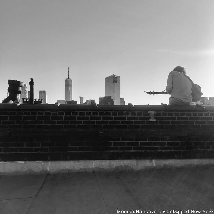 man playing guitar on rooftop