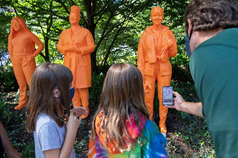 Girls looking at IfThenSheCan sculpture