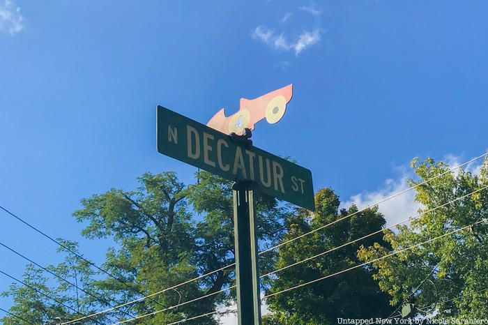 Street sign in Watkins Glen notes former history as a racetrack with a racing car