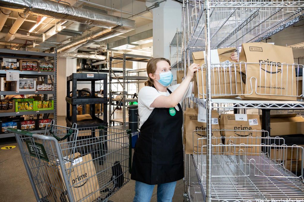 Shopper putting bags on shelf at Whole Foods Online Only Store in Industry City