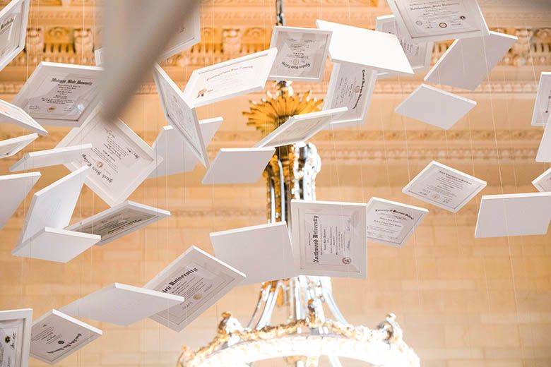 Da Vinci of Debt diplomas flying near light in grand central