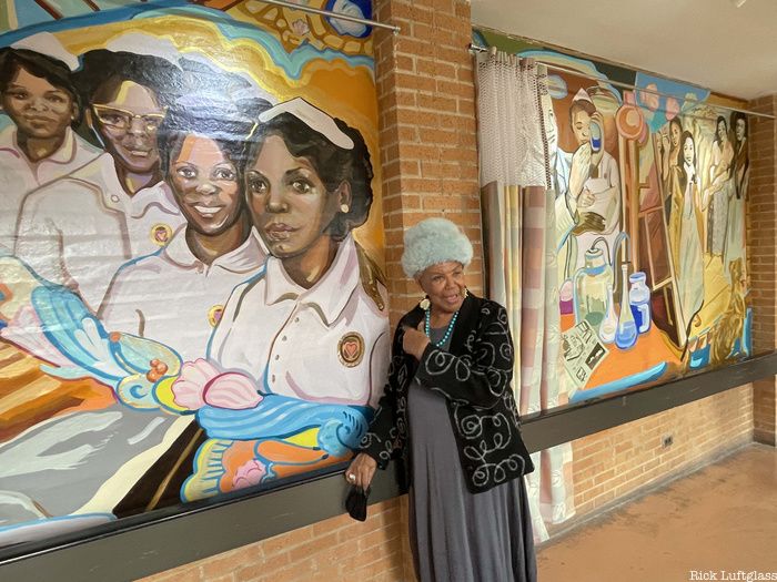 Virginia Allen pointing at Sea View Hospital Mural of Black Angels