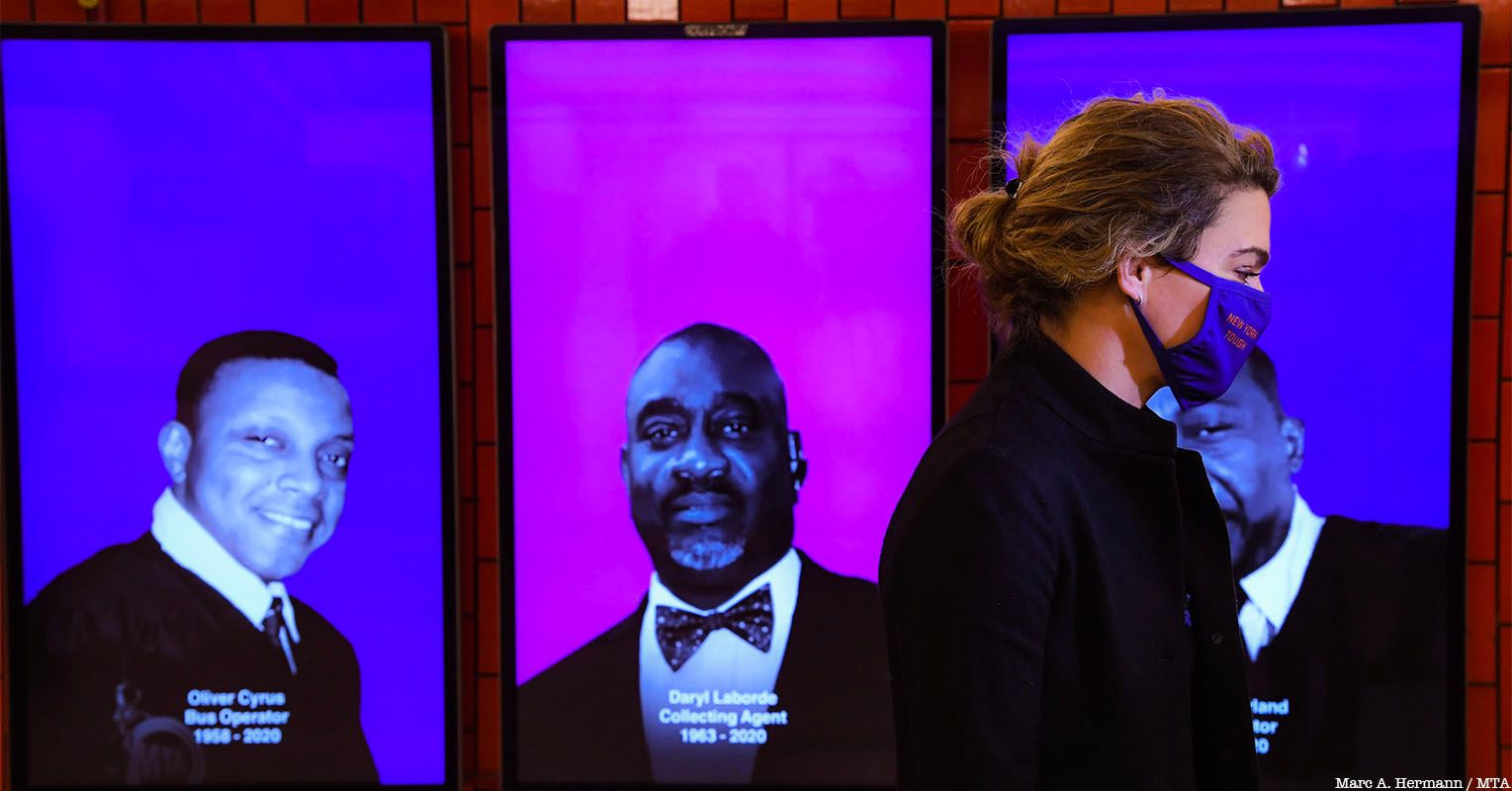 Sarah Feinberg in front of TRAVELS AFAR digital memorial to covid workers lost in pandemic