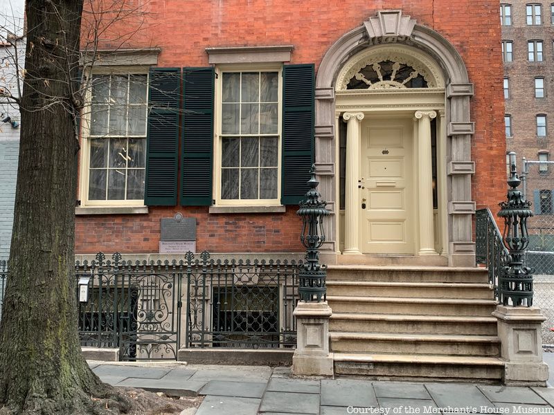 Two windows and a door are seen on the front entrance to the Merchant House Museum, a famously haunted place in NYC.