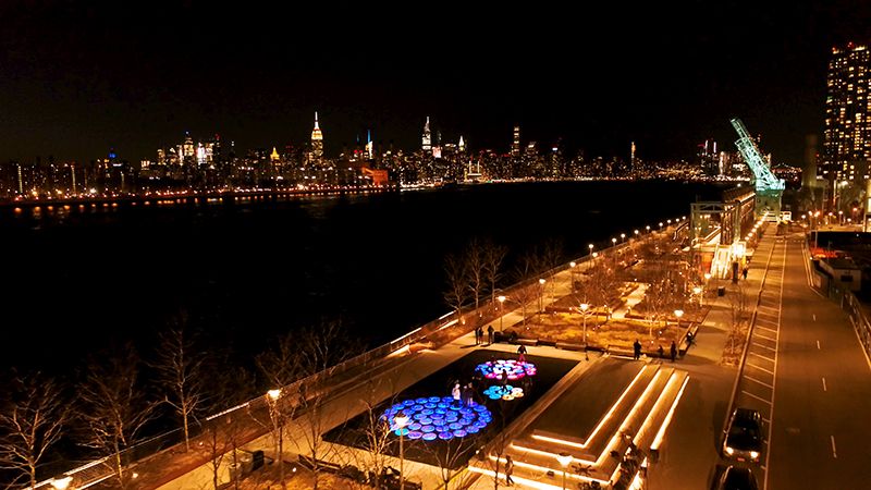 Aerial shot from a distance of Reflect with NYC skyline