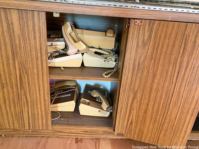 vintage telephones in cabinet