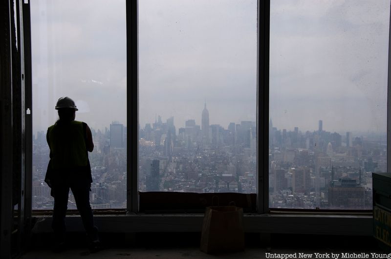 Person wearing hard hat looking out from window of 1 WTC