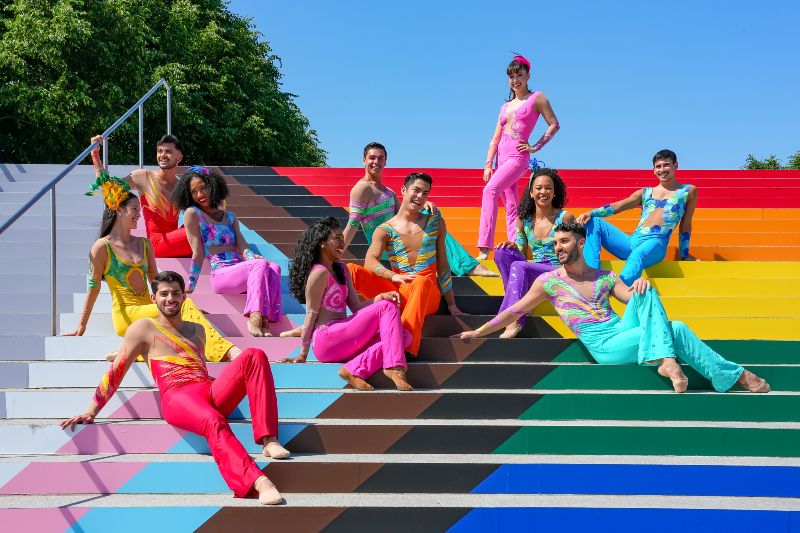 dancers pose on progress pride flag stairs