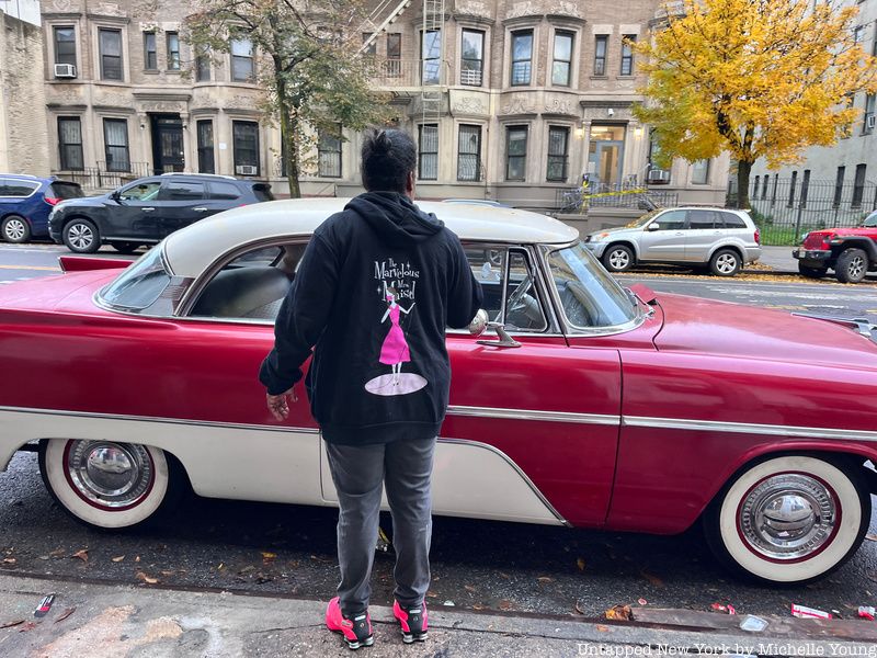 Staff with Marvelous Mrs. Maisel sweatshirt in front of vintage car