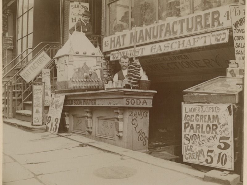 A man serves pretzels outside a confectionary in NYC in 1900.