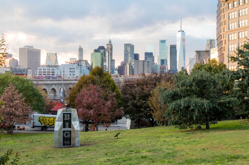 Biggie Smalls sculpture in Brooklyn set against the Manhattan skyline