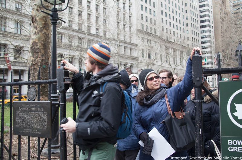 Tourgoers touching the top of Bowling Green Fence, a remnant of colonial NYC