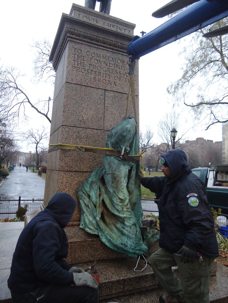 Two worked remove the armless and headless fame statue in the Bronx