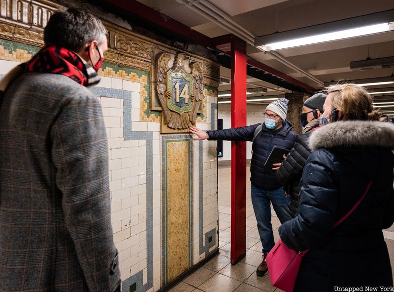 Tourgoers look at an art installation at the 14th Street subway station