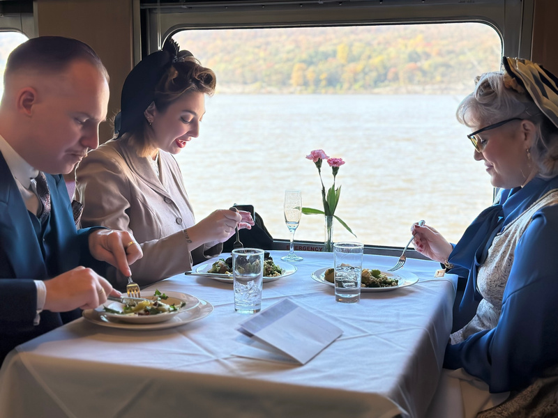 People in period attire inside a historic train