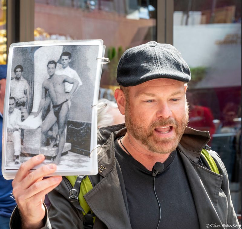 Justin Rivers holds up a photo of the model for Prometheus at Rockefeller Center