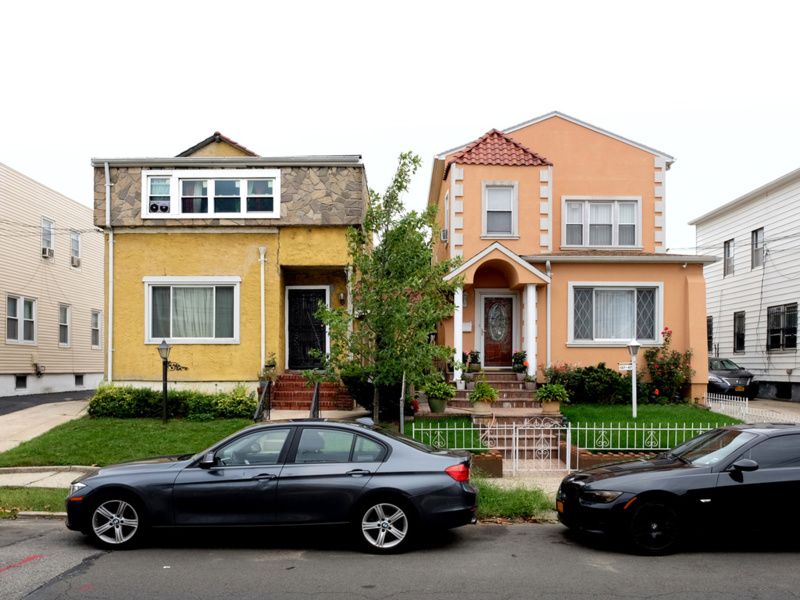 Two Queens houses with small lawns out front