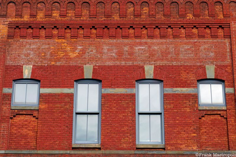 A fading ghost sign that says "Warehouse" on a red brick building