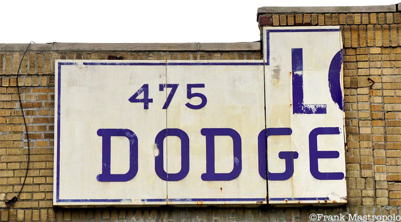 A severed ghost sign in Williamsburg, Brooklyn hangs over the former London Motors Dodge-Plymouth service center.