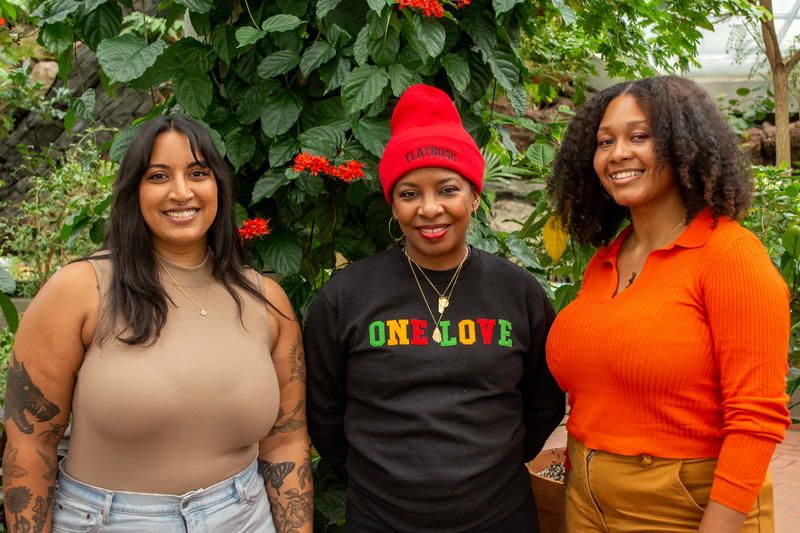 Three women standing at the Little Caribbean Trees exhibit