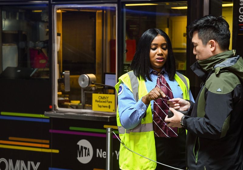 MTA customer service worker helping a rider