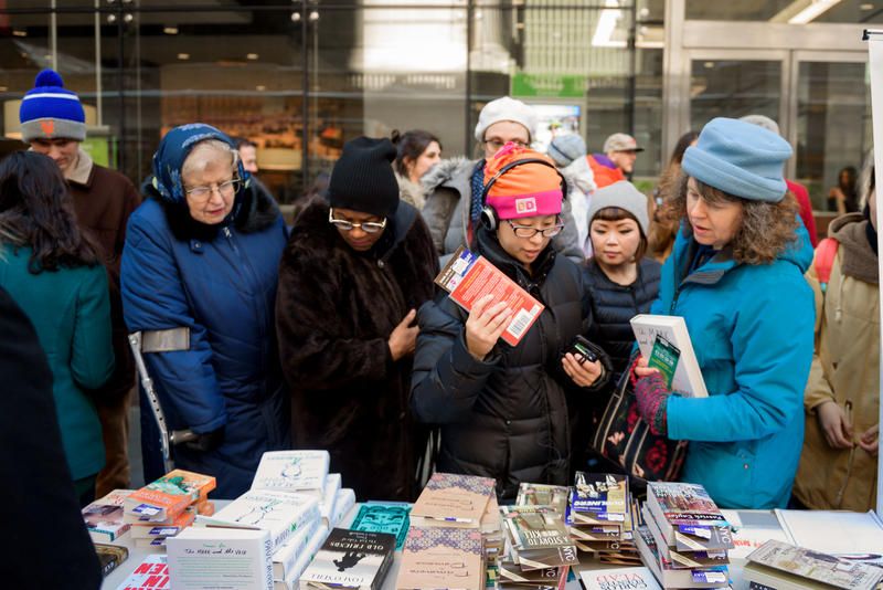 People grab books off a table at the annual St. Patrick's Day in NYC book day