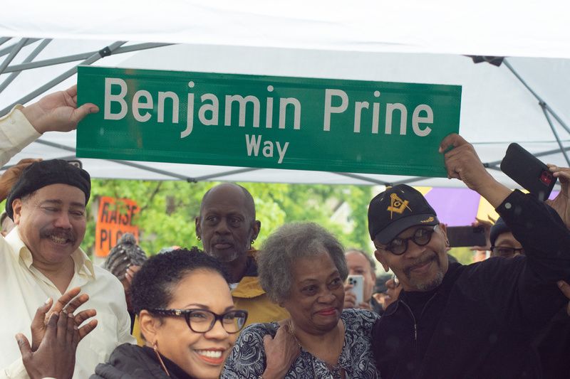 Descendants of Benjamin Prine hold up a sign that says Benjamin Prine way