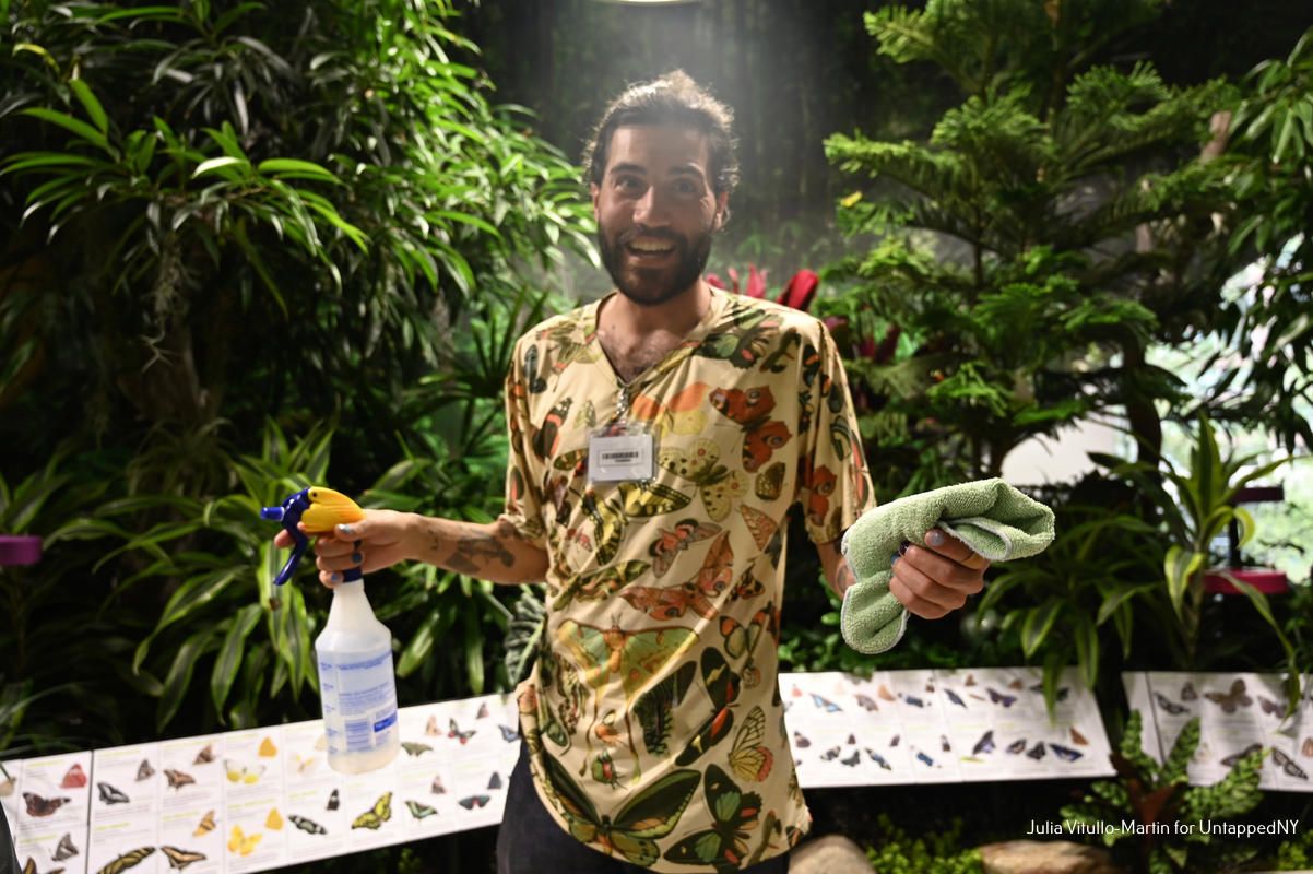 A volunteer inside the butterfly vivarium at the Gilder Center for Science, Education, and Innovation