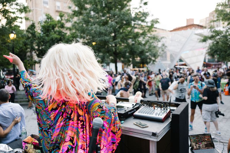 Image from last year's Dance for a Memorial featuring the DJ and attendees with wireless headphones in the background