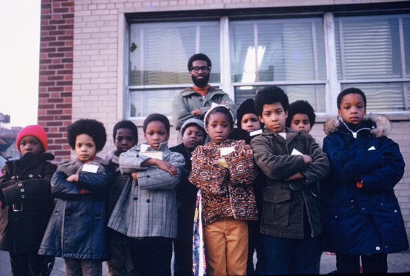 A group of schoolchildren standing with their arms crossed