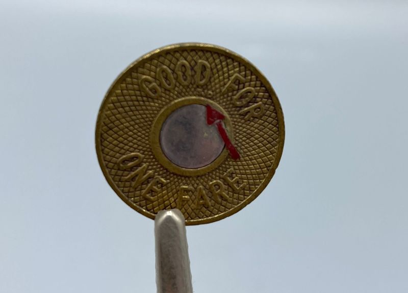 A subway token with initials on it